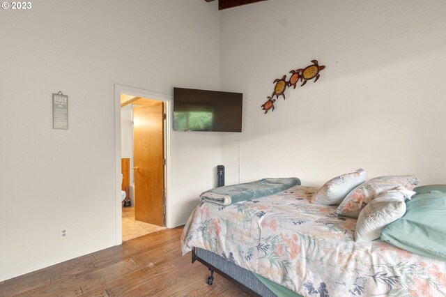 bedroom with hardwood / wood-style flooring, vaulted ceiling with beams, and wooden ceiling