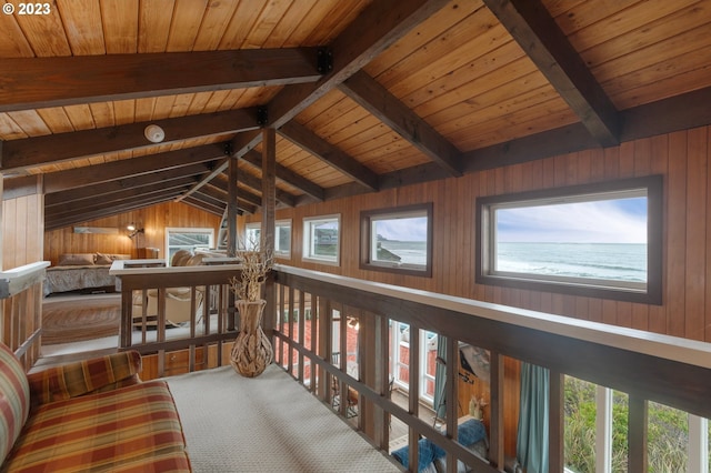 sitting room featuring vaulted ceiling with beams, plenty of natural light, wood ceiling, and wooden walls