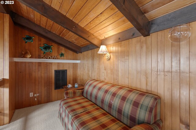 carpeted living room featuring wooden walls, lofted ceiling with beams, and wooden ceiling