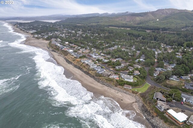 drone / aerial view featuring a water view and a beach view