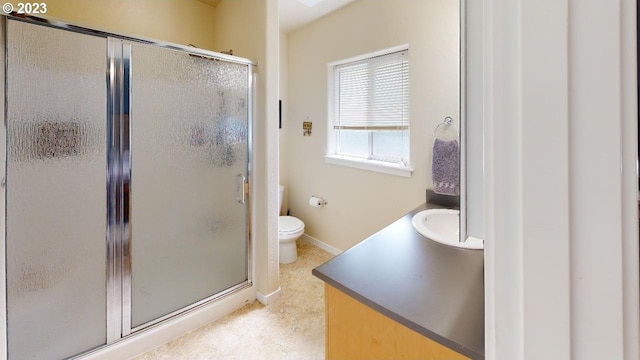 bathroom featuring toilet, a shower with door, and vanity