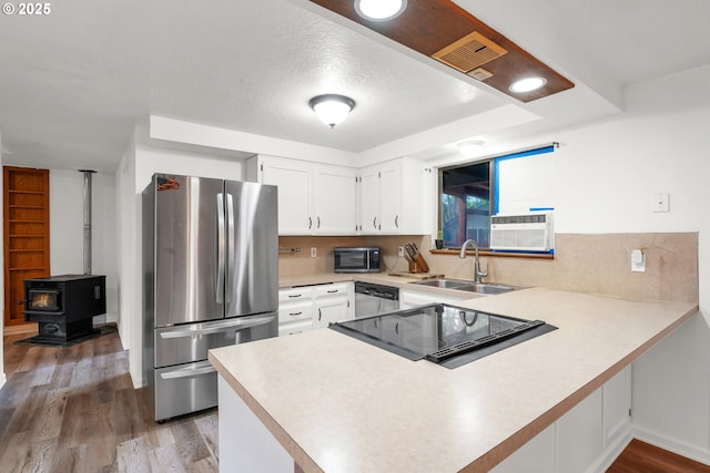 25191 Berry Ln, Veneta, OR 97487 - kitchen with appliances with stainless steel finishes, a peninsula, light countertops, white cabinets, and wood finished floors