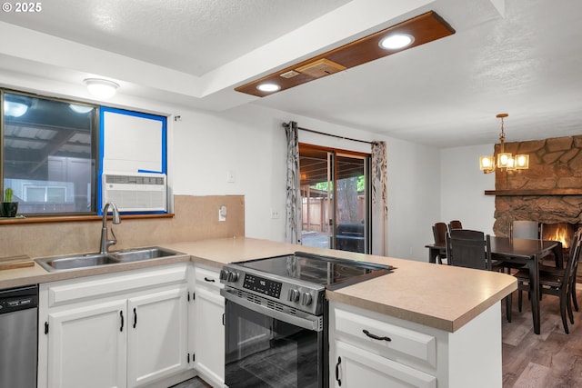 25191 Berry Ln, Veneta, OR 97487 - kitchen with stainless steel appliances, a peninsula, light wood finished floors, white cabinetry, and light countertops