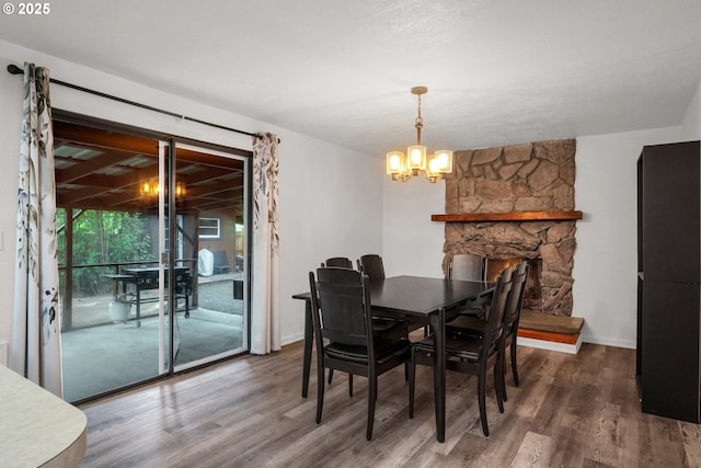 25191 Berry Ln, Veneta, OR 97487 - dining space with wood finished floors, a chandelier, and a stone fireplace