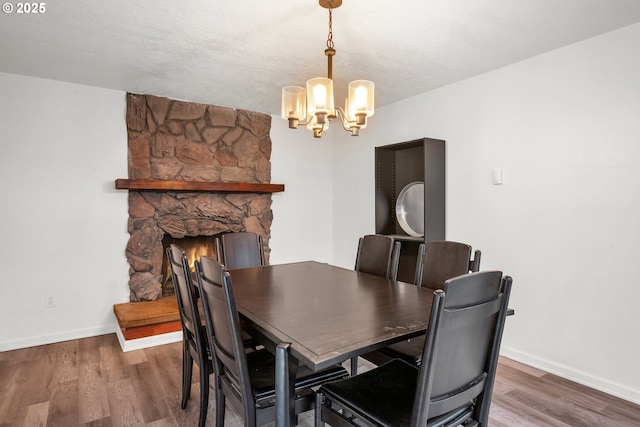 25191 Berry Ln, Veneta, OR 97487 - dining area with a chandelier, wood finished floors, and a stone fireplace