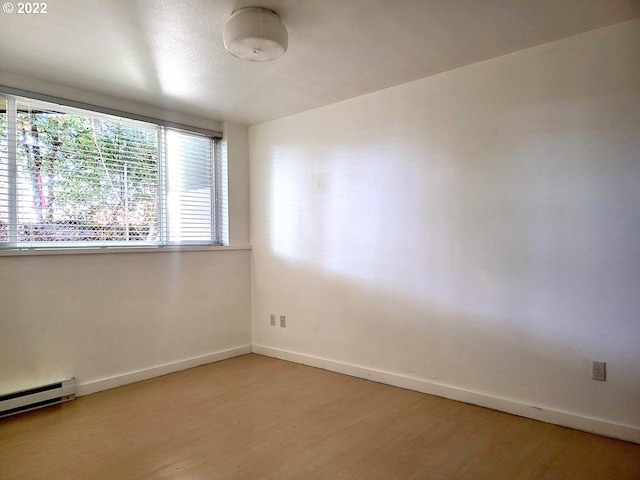 spare room with hardwood / wood-style flooring and baseboard heating