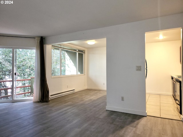 unfurnished living room with hardwood / wood-style flooring and baseboard heating