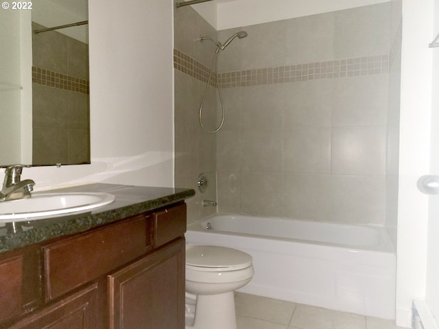 full bathroom featuring toilet, vanity, tile patterned floors, and tiled shower / bath combo