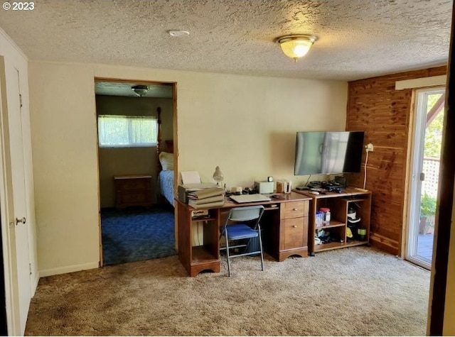 carpeted office with wooden walls and a textured ceiling