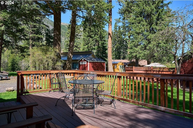 wooden terrace featuring a yard and a storage shed