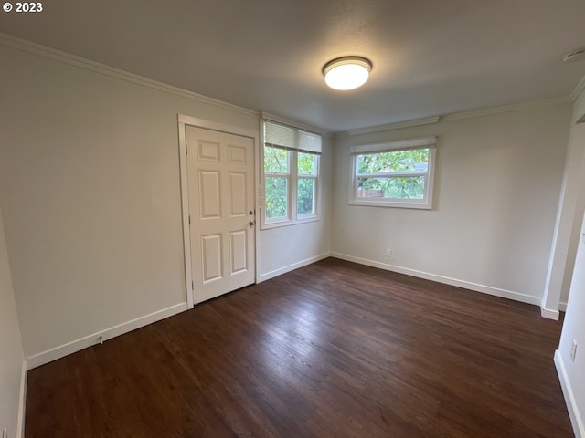 unfurnished room with dark hardwood / wood-style flooring and ornamental molding