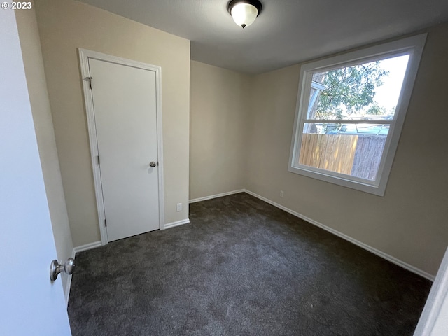 empty room featuring dark colored carpet