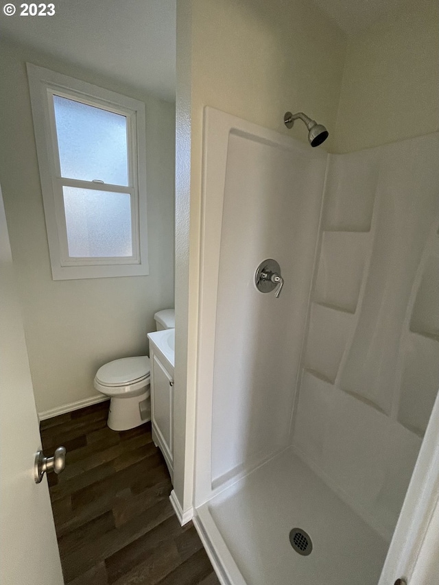 bathroom with walk in shower, toilet, vanity, and wood-type flooring