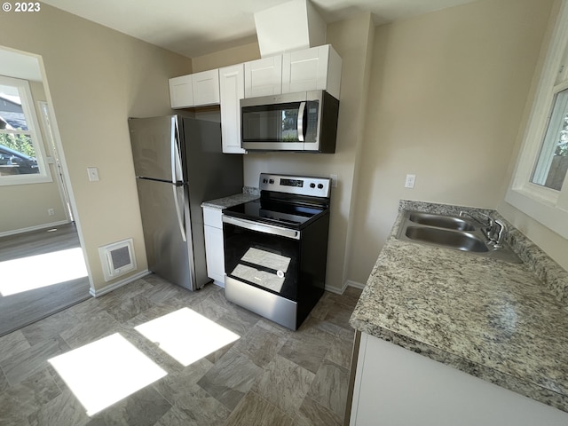 kitchen featuring hardwood / wood-style floors, stainless steel appliances, white cabinetry, and sink