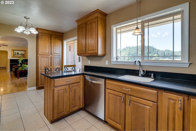 kitchen with a healthy amount of sunlight, an inviting chandelier, sink, light tile floors, and dishwasher