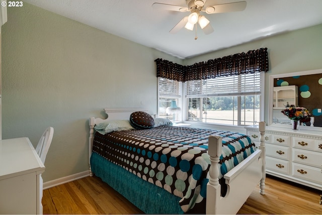 bedroom with light hardwood / wood-style floors and ceiling fan