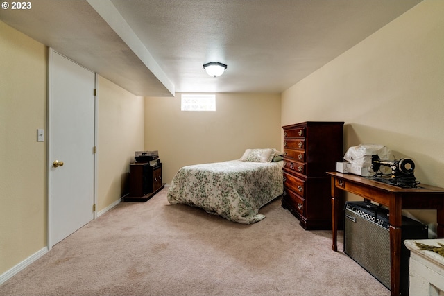 bedroom featuring light carpet and a textured ceiling