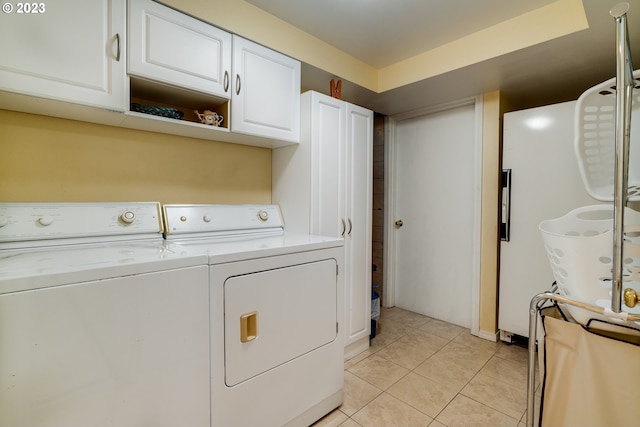 washroom featuring separate washer and dryer, light tile floors, and cabinets