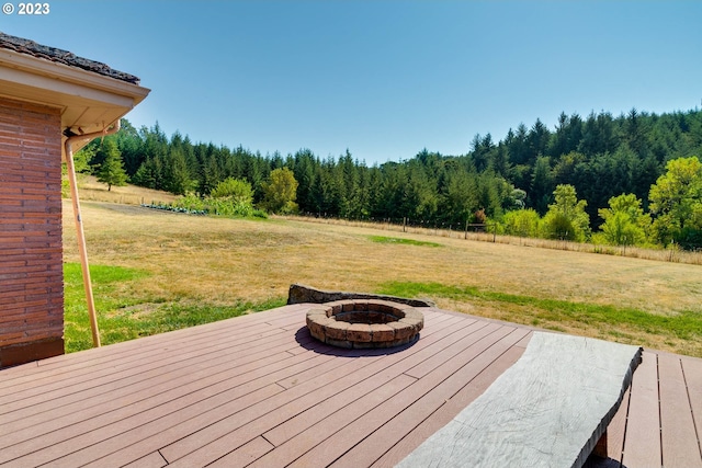 wooden terrace featuring a fire pit and a yard