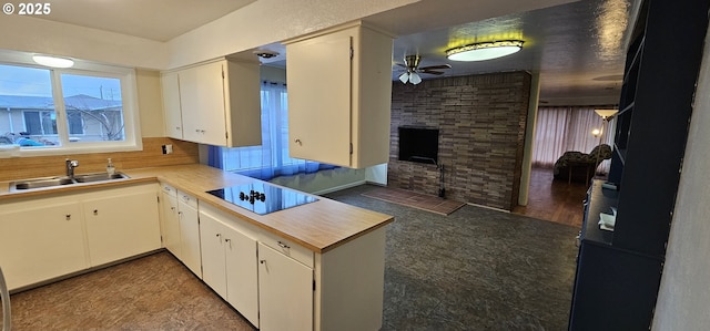 29545 Bailor St, Gold Beach, OR 97444 - kitchen with a sink, black electric stovetop, a ceiling fan, a fireplace, and light countertops