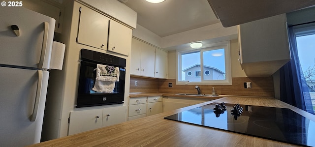 29545 Bailor St, Gold Beach, OR 97444 - kitchen with black appliances, tasteful backsplash, white cabinets, a sink, and light countertops