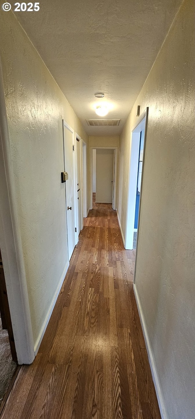 29545 Bailor St, Gold Beach, OR 97444 - hall featuring wood finished floors, baseboards, a textured wall, and a textured ceiling