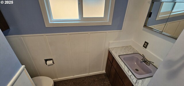 29545 Bailor St, Gold Beach, OR 97444 - half bath featuring a decorative wall, vanity, toilet, healthy amount of natural light, and wainscoting