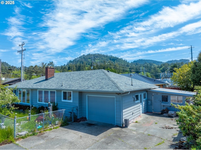 29545 Bailor St, Gold Beach, OR 97444 - ranch-style house featuring an attached garage, fence, a chimney, concrete driveway, and a mountain view