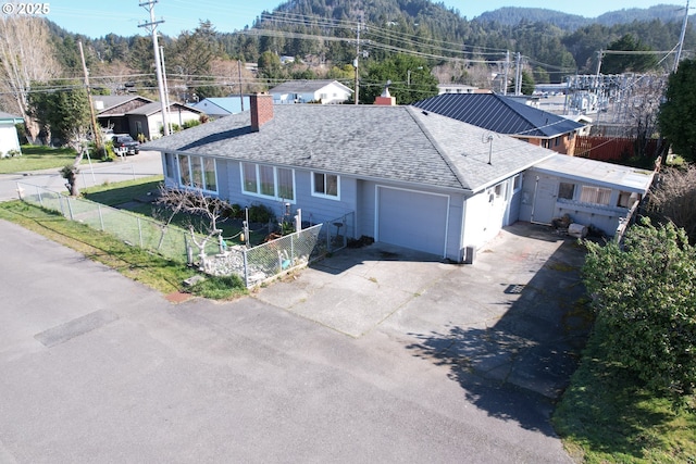 ranch-style house featuring a chimney, a shingled roof, fence, a garage, and driveway