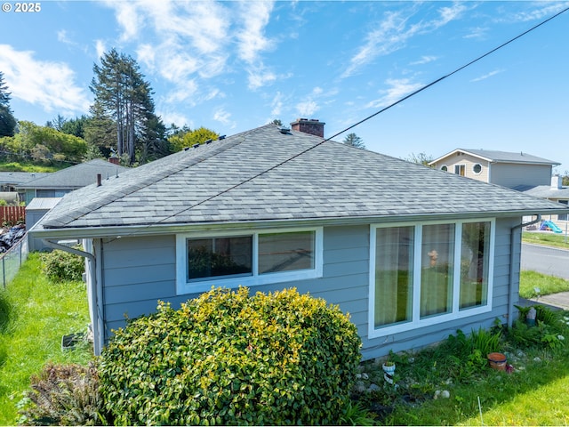 29545 Bailor St, Gold Beach, OR 97444 - view of home's exterior with fence, a chimney, and roof with shingles