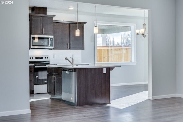 kitchen featuring appliances with stainless steel finishes, dark brown cabinetry, and pendant lighting