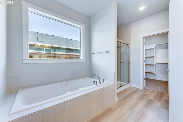 bathroom with hardwood / wood-style flooring and independent shower and bath