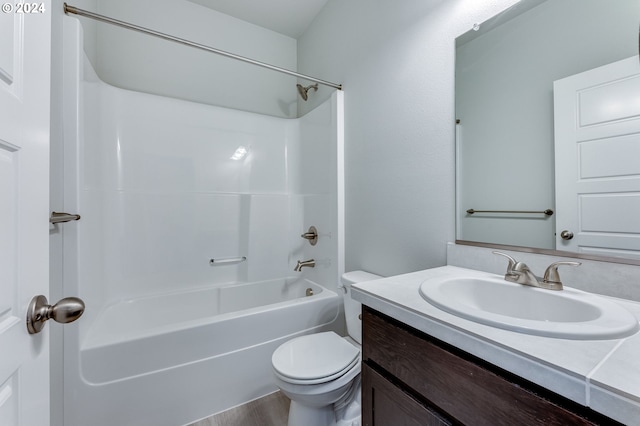 full bathroom featuring vanity, hardwood / wood-style floors, washtub / shower combination, and toilet