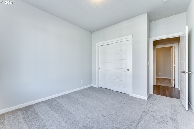 unfurnished bedroom with carpet floors and a closet