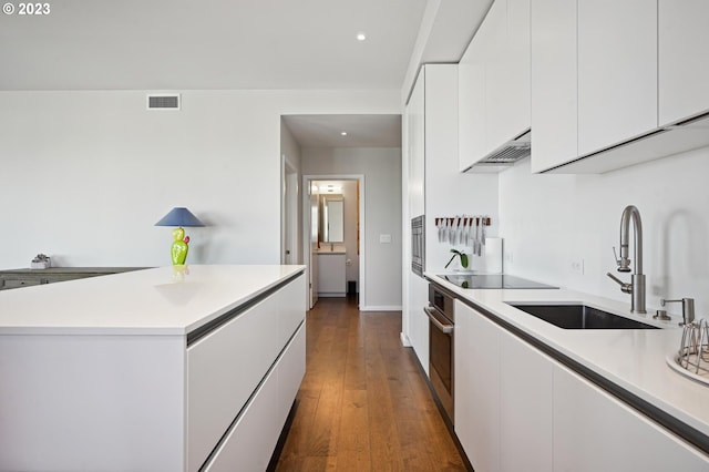 kitchen featuring appliances with stainless steel finishes, a center island, white cabinetry, and dark hardwood / wood-style flooring