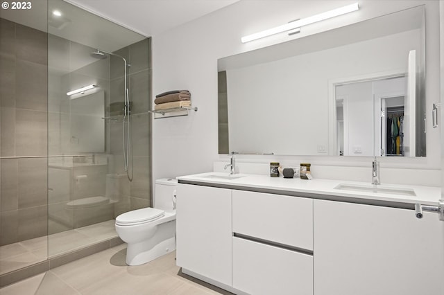 bathroom with toilet, dual bowl vanity, tile flooring, and a shower with shower door