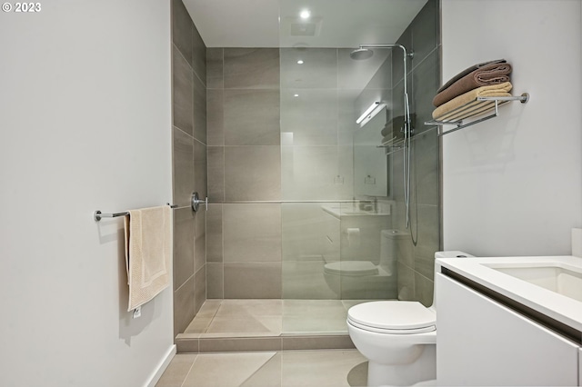 bathroom with vanity, tile floors, toilet, and a shower with shower door