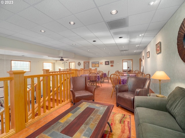 tiled living room with a paneled ceiling and ceiling fan