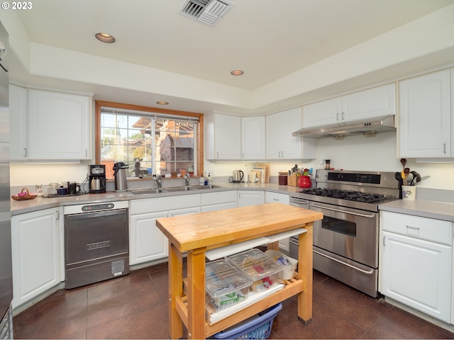 kitchen with black dishwasher, white cabinetry, range with two ovens, and sink