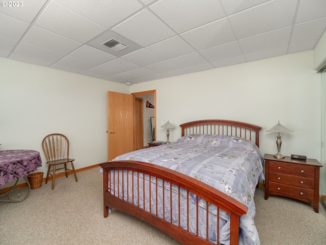 bedroom featuring a paneled ceiling and light carpet