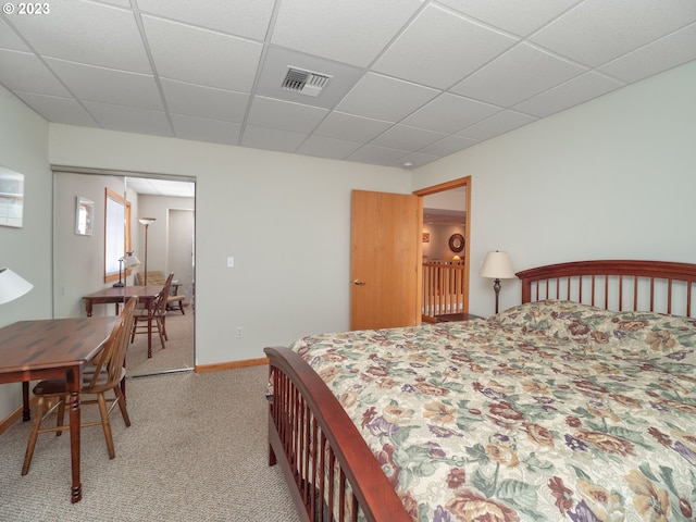 carpeted bedroom featuring a paneled ceiling and a closet