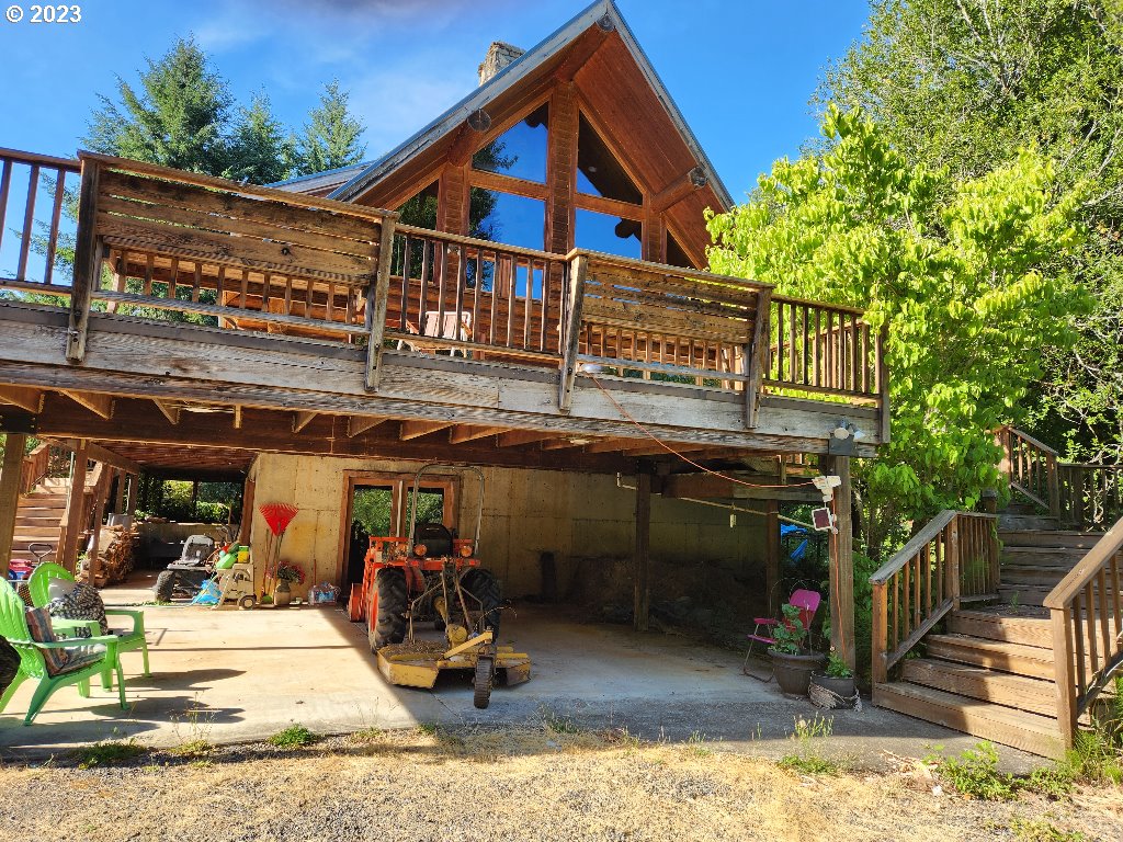 back of house with a deck and a patio area