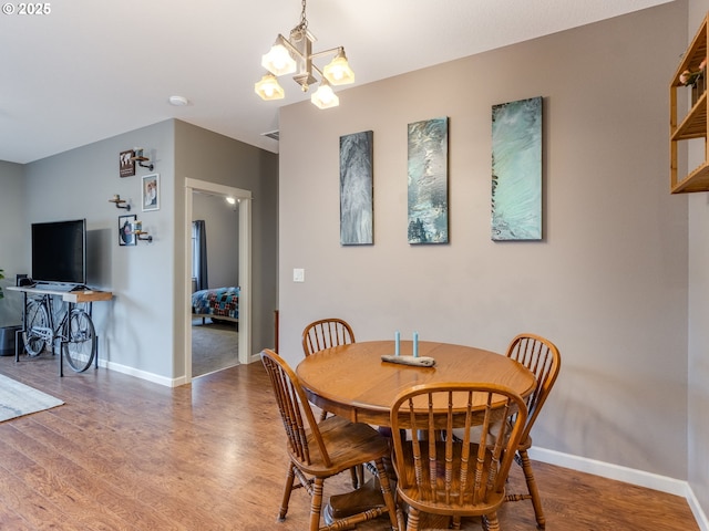 dining area with an inviting chandelier, baseboards, and wood finished floors