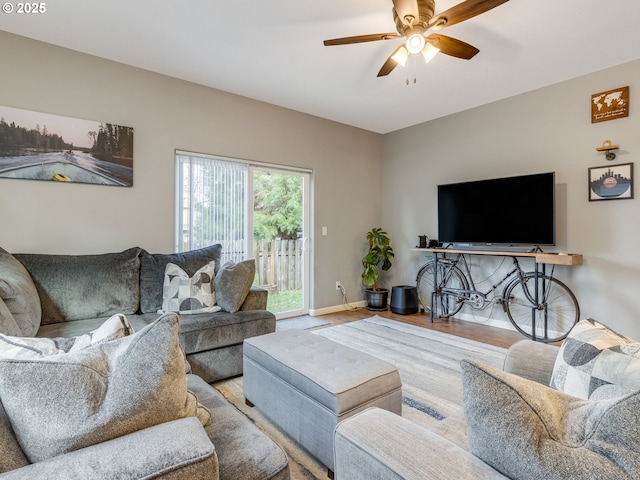 living area featuring ceiling fan, baseboards, and wood finished floors