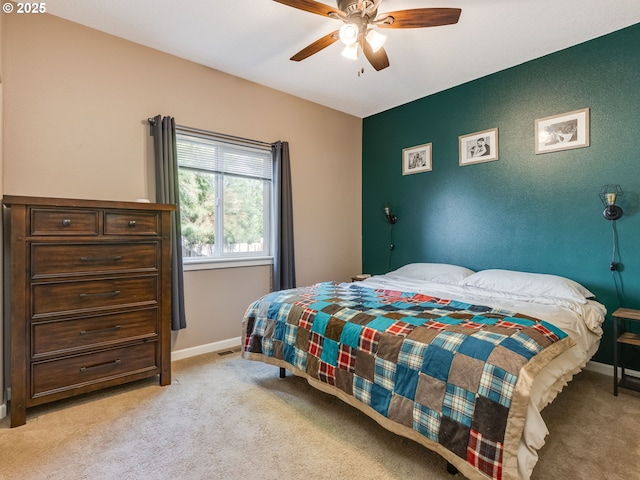 bedroom with visible vents, baseboards, ceiling fan, and light colored carpet