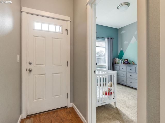 foyer entrance featuring wood finished floors and baseboards