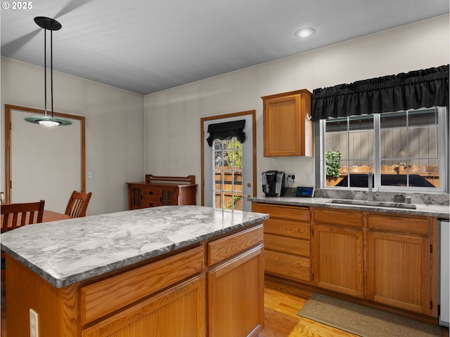 65679 E Alpine Way, Rhododendron, OR 97049 - kitchen featuring a sink, brown cabinetry, a center island, light wood-type flooring, and pendant lighting