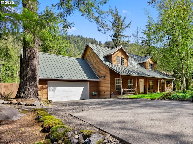 65679 E Alpine Way, Rhododendron, OR 97049 - chalet / cabin with an attached garage, a standing seam roof, covered porch, driveway, and metal roof