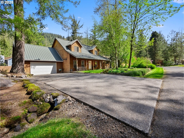 65679 E Alpine Way, Rhododendron, OR 97049 - view of front facade with a garage, metal roof, a porch, and driveway