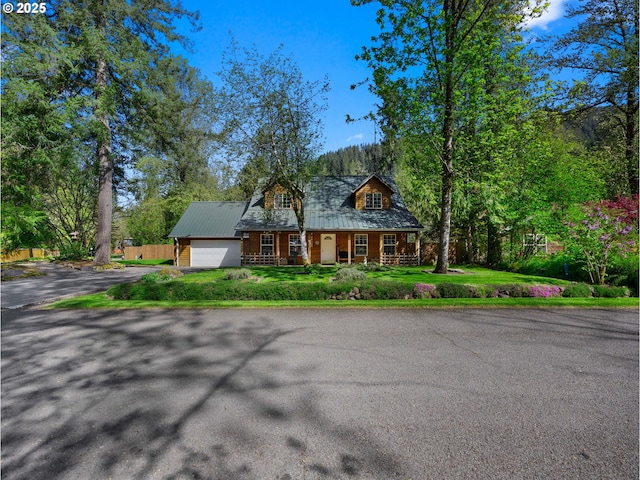 65679 E Alpine Way, Rhododendron, OR 97049 - view of front facade with fence, a garage, covered porch, driveway, and metal roof